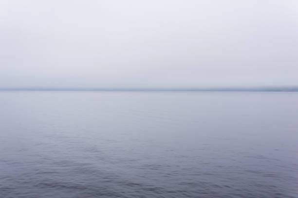 istock cold body of water with a distant shore hidden by fog 1174647607