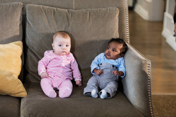 istock Two newborn babies sitting on couch 1174651612