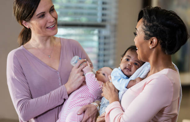istock Two mothers with their babies, holding and feeding 1174651746