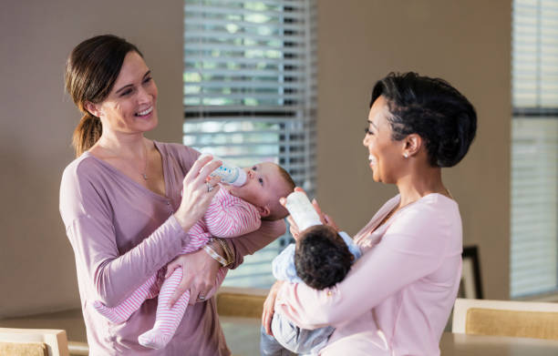 istock Two mothers with their babies, bottle-feeding 1174652299