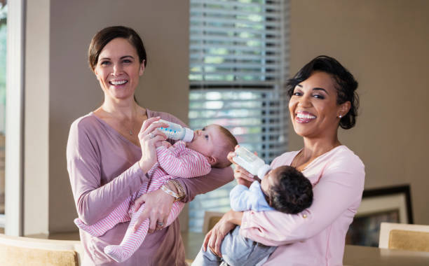 istock Two mothers with their babies, bottle-feeding 1174652443