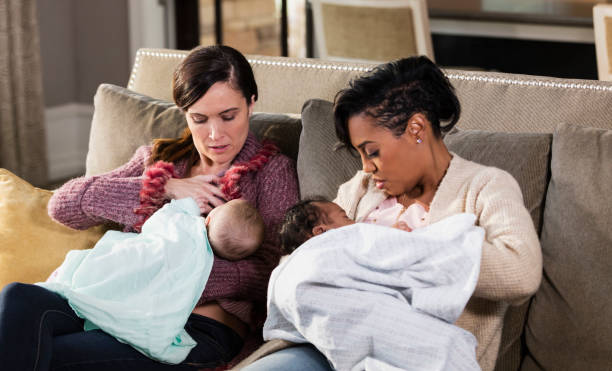 istock Two mothers and babies on sofa, nursing 1174652741