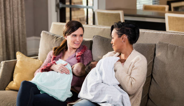istock Two mothers and babies on sofa, nursing 1174652871