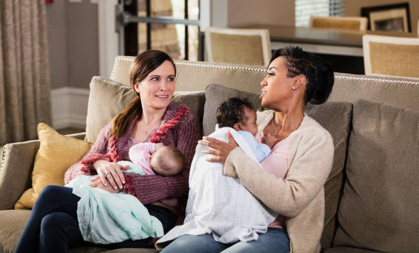 istock Two mothers and babies on sofa, nursing 1174652872