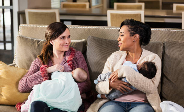 istock Two mothers and babies on sofa, nursing 1174652931