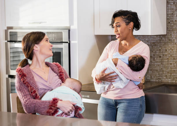 istock Two mothers nursing babies, conversing in kitchen 1174653823
