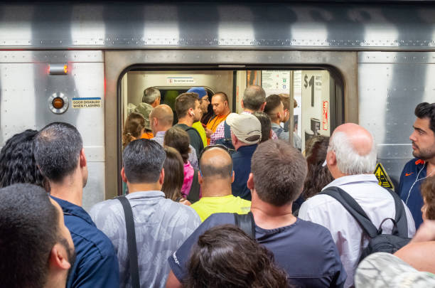 Manhattan, New York, USA -July 26, 2019:  Long Island Railroad commuter train, crowded with Early afternoon rush hour commuters leaving New York from Pennsylvania Station. This train to Babylon was 2 cars short. The LIRR takes commuters back and forth from Long Island and Queens to New York City Penn Station and Brooklyn.