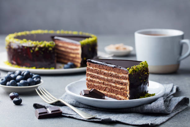 шоколадный торт на белой тарелке. серый каменный фон. заживать. - cake chocolate cake chocolate gateaux стоковые фото и изображения