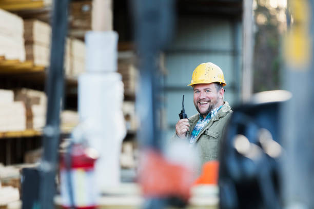 istock Hispanic man on walkie talkie, working in lumber yard 1174655302