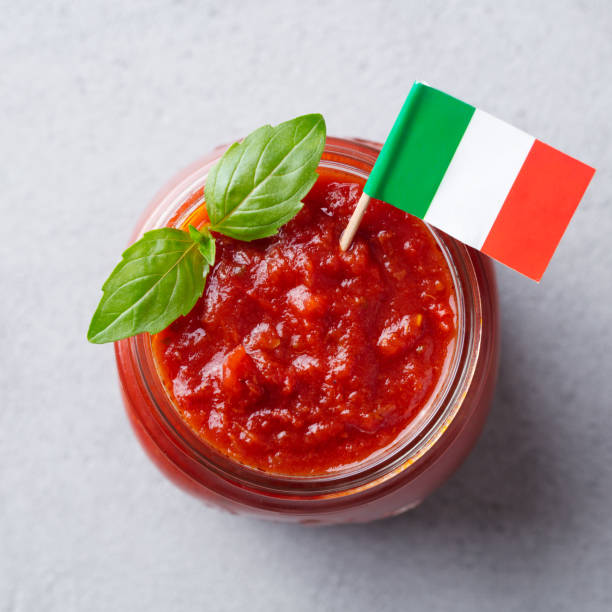 tradycyjny sos pomidorowy z bazylią w szklanym słoiku z włoską flagą. widok z góry. szare tło. - tomato sauce jar zdjęcia i obrazy z banku zdjęć