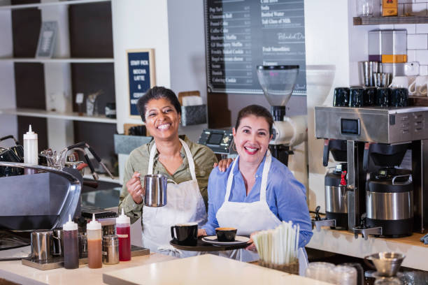 istock Two women working in coffee shop, preparing drink 1174657314