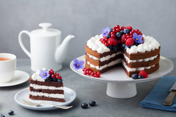 pastel de chocolate con crema batida y bayas frescas. fondo de piedra gris. - tart dessert plate white fotografías e imágenes de stock