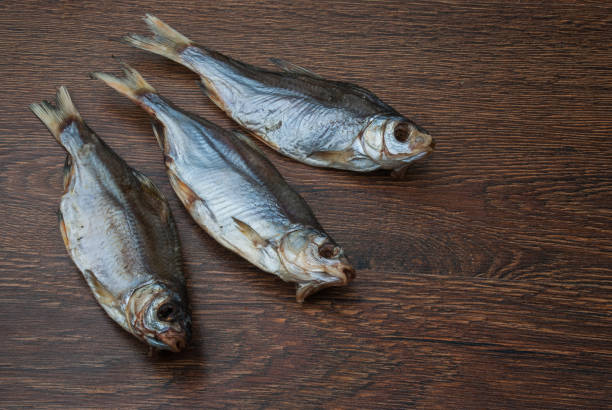 istock some dried fish on a dark wooden background 1174658830