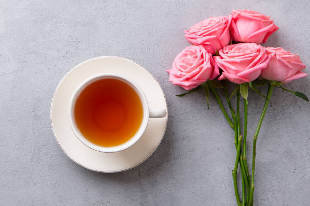 istock Cup of tea with pink rose. Top view. Copy space. Grey stone background. 1174658867