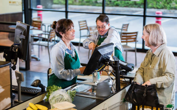istock Customer and employees at supermarket checkout 1174658894