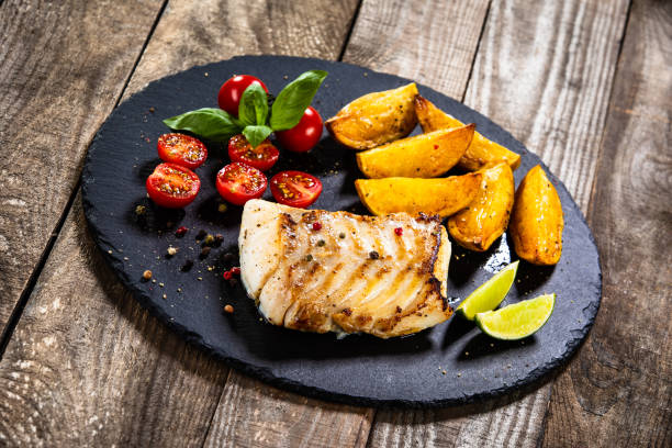 istock Fried cod fillet with baked potatoes and vegetables 1174659711