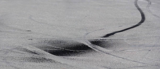 istock Black burnt rubber drift traces made by motorcycle on asphalt. Braking distances. Traces from the tire from emergency braking on asphalt. Emergency braking skid,  traffic accident, panoramic view 1174660621