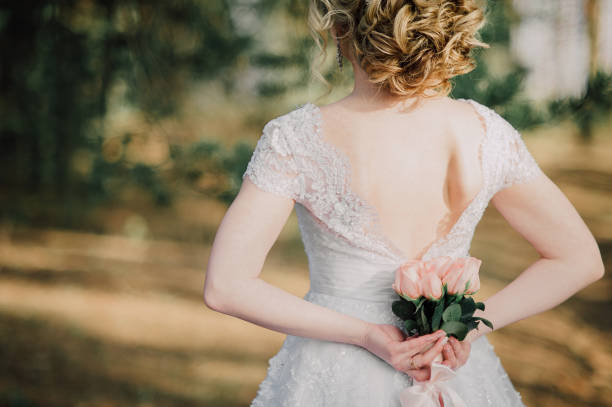 istock Back of beautiful bride with bridal bunch 1174677878