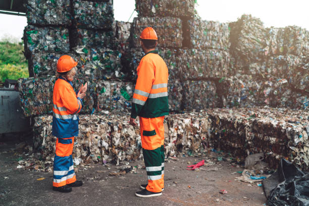 istock Recycling center workers examining paper waste ready for recycling 1174679889