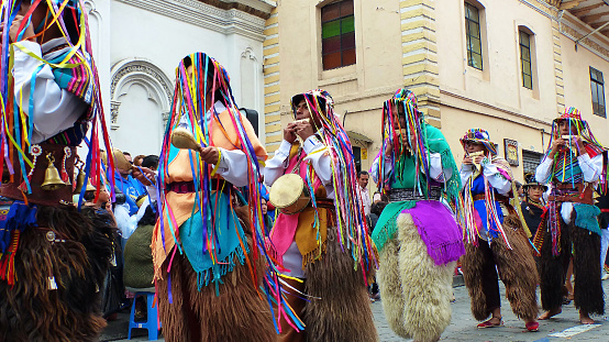 Cuenca, Ecuador - December 24, 2018: Christmas parade in Cuenca city Pase del Nino Viajero (Traveling Child) in honor of baby Jesus. Group of indigenous men from canton Caymbe of Pichincha province dance durante parade