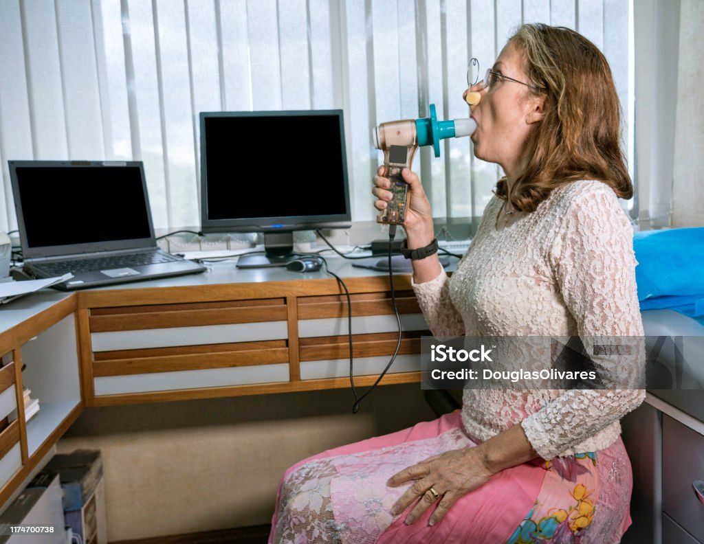 Reife Frau, die Lungenfunktionstest und Spirometrie durchführt - Lizenzfrei Raucherlunge Stock-Foto