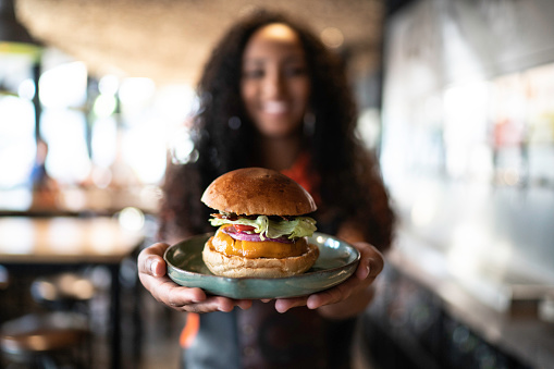 Waitress holding / showing a sandwich