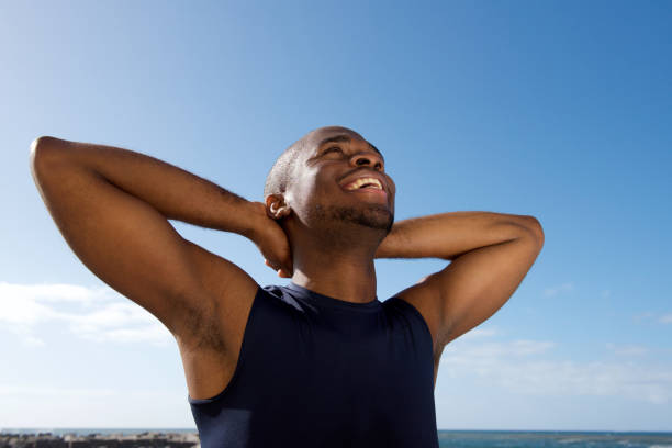 istock healthy happy young black man smiling with hands behind head 1174712276