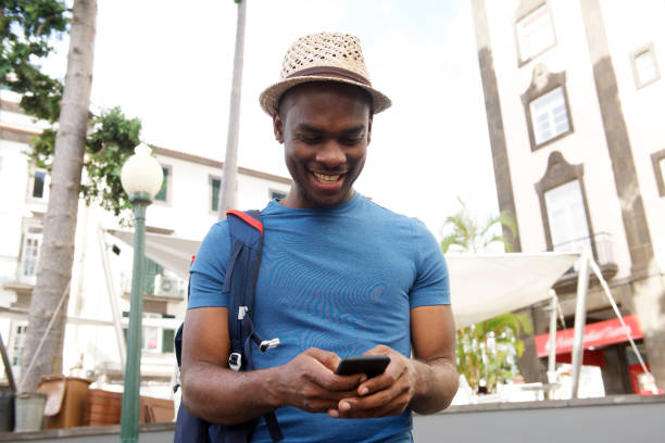 istock smiling young black man looking at cellphone outdoors in city 1174712623
