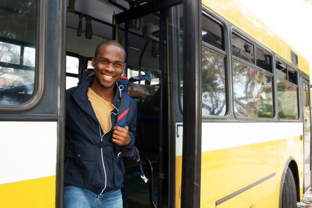 felice giovane uomo di viaggio afroamericano con borsa scendere autobus - transportation bus mode of transport public transportation foto e immagini stock