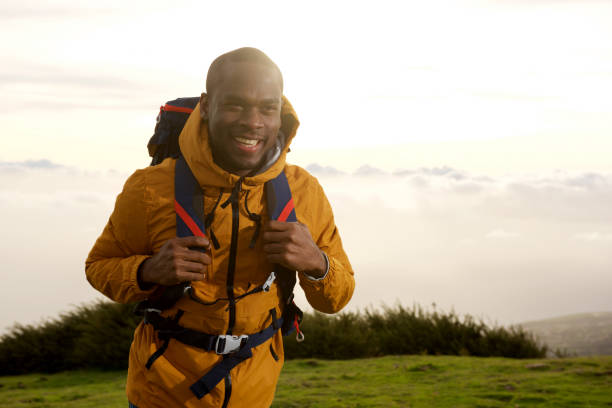 istock happy african american man walking with backpack in nature 1174712675