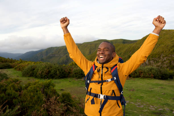 istock happy african american backpacker standing outdoors with arms raised 1174712690