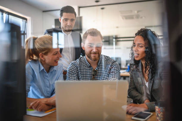 istock Cheerful Young Businesspeople Exchanging Ideas with Laptop 1174712917