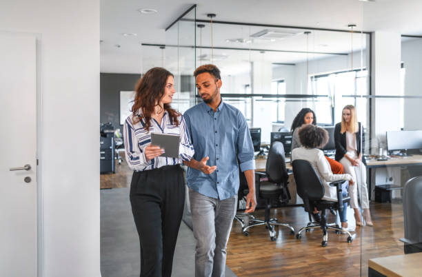 istock African and Caucasian Businesspeople Walking Through Office 1174712929