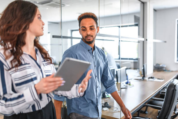 istock African and Caucasian Businesspeople Walking Through Office 1174712933