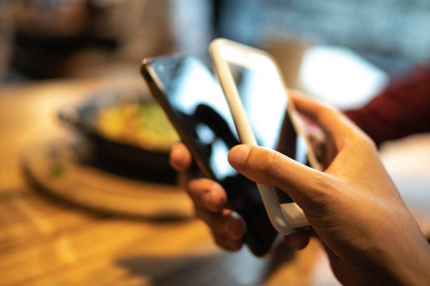 istock People transferring money using contactless technology on smartphones 1174720157