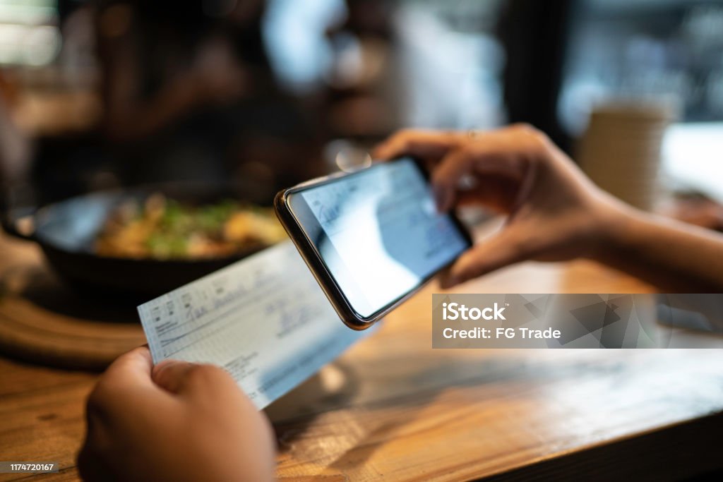 Man depositing check by phone in the restaurant Mobile Phone Stock Photo