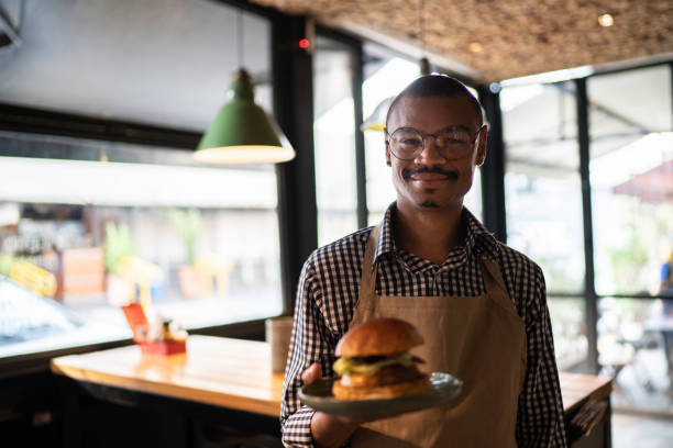 istock Business owner or waiter showing a hambuguer 1174720264