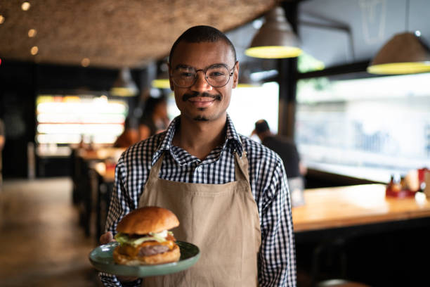 istock Business owner or waiter showing a hambuguer 1174720269