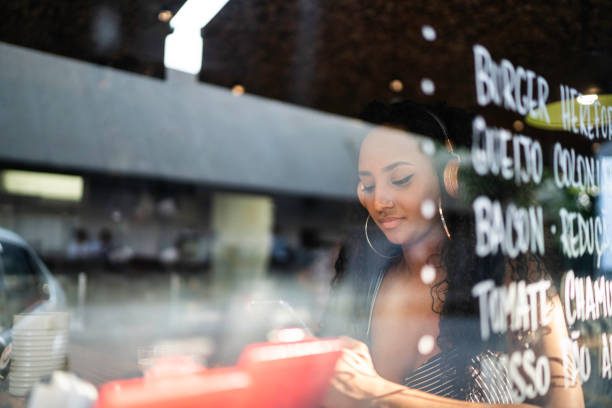 istock Young woman in a restaurant using smartphone 1174720275