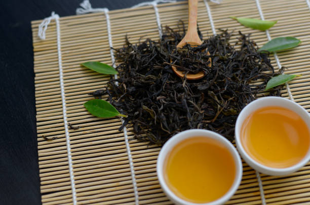 istock Chinese hot tea in white cup with tea leaf and wooden spoon on table 1174734876