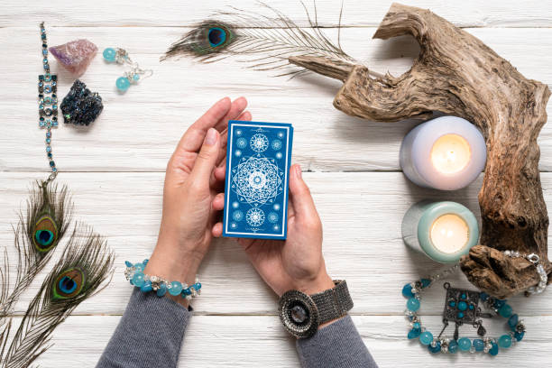 Tarot cards. Fortune teller woman and a blue tarot cards over white wooden table background. Tarot Card Reading stock pictures, royalty-free photos & images