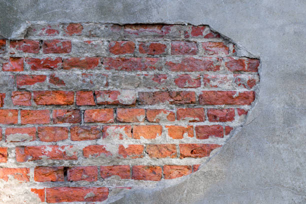 istock A vertical red brick wall with a damaged patch of gray stucco. Elements for design. 1174758839