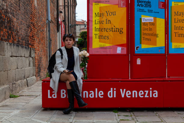 Girl sitting on bench during the 58th International Art exhibition of Venice biennale VENICE, ITALY - MAY, 09: Girl sitting on bench during the 58th International Art exhibition of Venice biennale titled May You Live In Interesting Times  on May 09, 2019"r venice biennale stock pictures, royalty-free photos & images