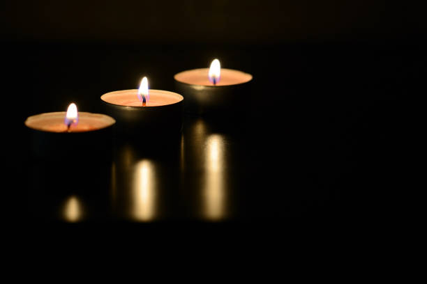 istock Three burning candles close up in the darkness. Mystery background 1174766441
