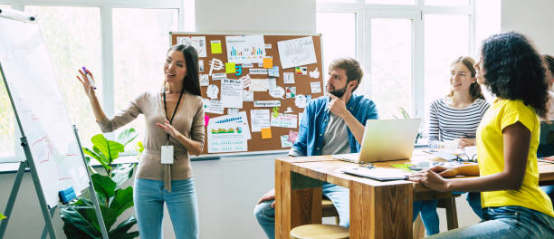 보드 룸에 서있는 동안 비즈니스 프리젠 테이션을 수행하는 성공적인 자신감 현대 젊은 사업가. 공동 작업 사무실에서 팀을 시작하십시오. - brainstorming team learning business 뉴스 사진 이미지