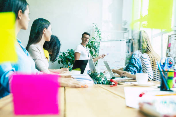 istock Successful confident modern young business man conducting a business presentation while standing in the board room. Start up team in co-working office. 1174766597