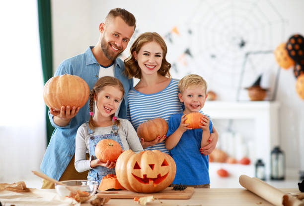 happy Halloween! family mother father and children cut pumpkin for holiday at home happy Halloween! family mother father and children cut a pumpkin for holiday at home Phobia stock pictures, royalty-free photos & images