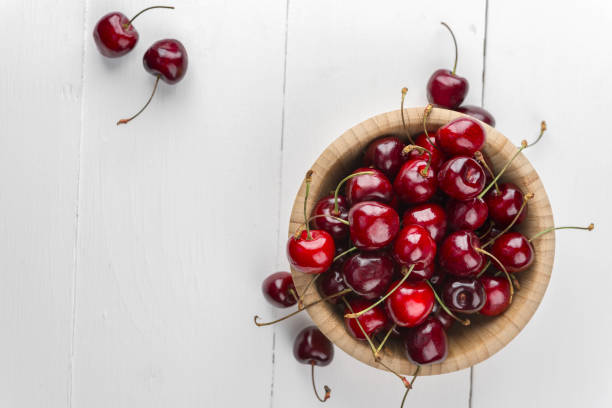 istock Cherry on a wooden plate on a white background 1174766849