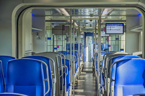 Hoorn, The Netherlands, September 13, 2019: blue seats, reflective ceiling and mondianesque partition walls in the interior of a new Dutch sprinter train
