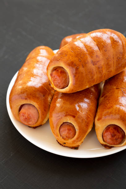 istock Homemade beef sausage kolache on a white plate on a black surface,  side view. Close-up. 1174768345
